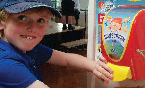 child using sunscreen dispenser